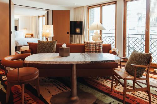 a hotel room with a living area with a table at Hotel SAX Paris, LXR Hotels & Resorts in Paris