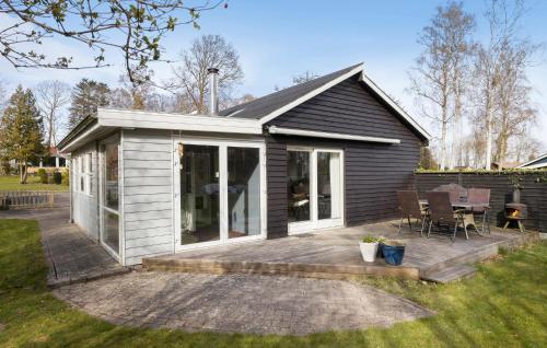 a small house with a deck in the yard at 3 Bedroom Beautiful Home In Allingåbro in Allingåbro