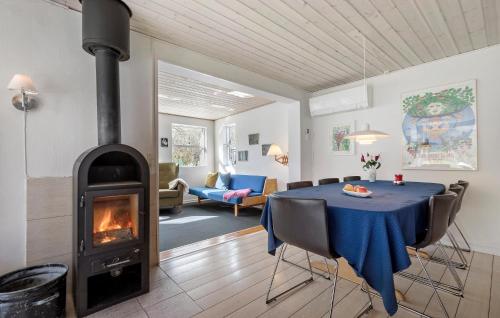 a living room with a table and a fireplace at 3 Bedroom Beautiful Home In Allingåbro in Allingåbro