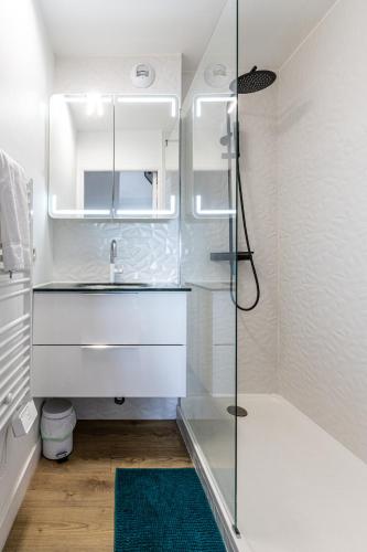 une salle de bain avec un lavabo et une douche en verre dans l'établissement L'Escale - Terrasse - Parking - Lave-linge - Wi-Fi, à Vannes