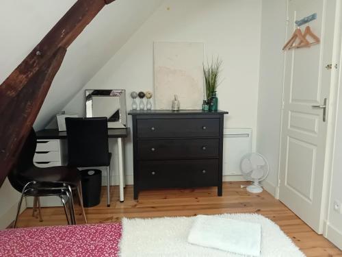 ein Schlafzimmer mit einer Kommode und einem Schreibtisch mit Spiegel in der Unterkunft CHEZ ISA chambre chez l'habitant Antoine in Montlouis-sur-Loire