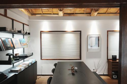una habitación con una mesa y una ventana con un ciego en Licensed Private hanok with Courtyard for 7, 10 min to metro, en Busan