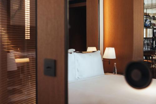 a bedroom with a bed with a white pillow at Hotel SAX Paris, LXR Hotels & Resorts in Paris
