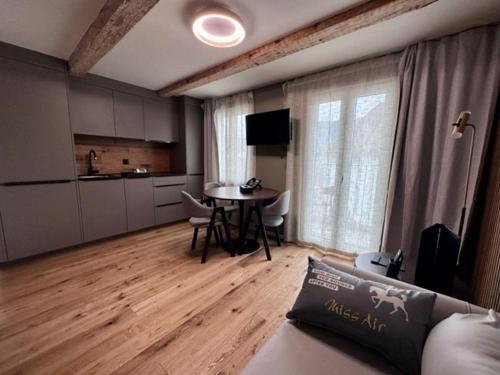 a living room with a table and a kitchen at BERG & BERG HOTEL - Kerns Self-Check-in in Kerns