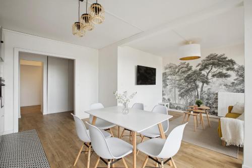 une salle à manger blanche avec une table et des chaises blanches dans l'établissement Magnifique Chambre dans une collocation design, à Rouen