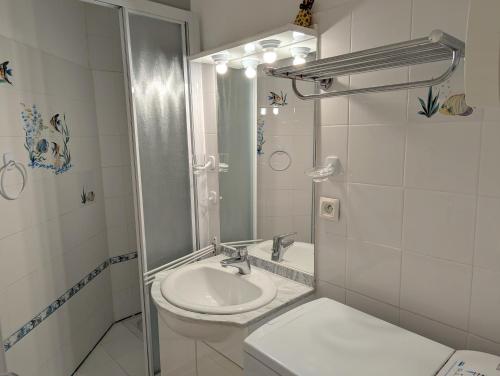 une salle de bain blanche avec un lavabo et des toilettes dans l'établissement Sol-y-Days Drakkar, Studio fonctionnel proche centre-ville et plages, au Grau-du-Roi