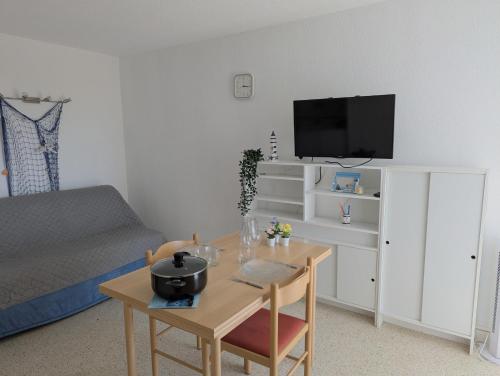 un salon avec une table et une télévision dans l'établissement Sol-y-Days Drakkar, Studio fonctionnel proche centre-ville et plages, au Grau-du-Roi