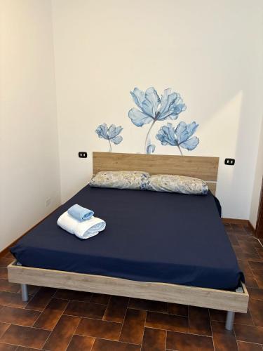 a bed with a blue bedspread and towels on it at Miro' dreams in Alzate Brianza