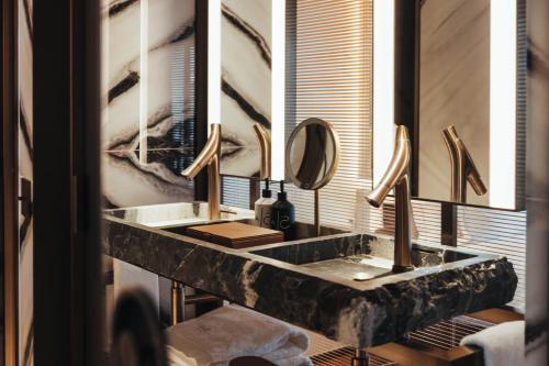 a bathroom with two sinks and a mirror at Hotel SAX Paris, LXR Hotels & Resorts in Paris