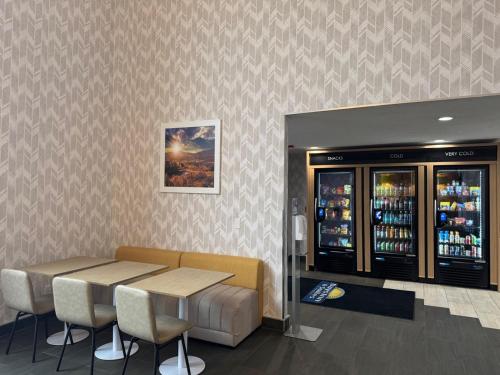 a restaurant with a table and chairs and a drink cooler at Days Inn & Suites by Wyndham Wausau in Wausau