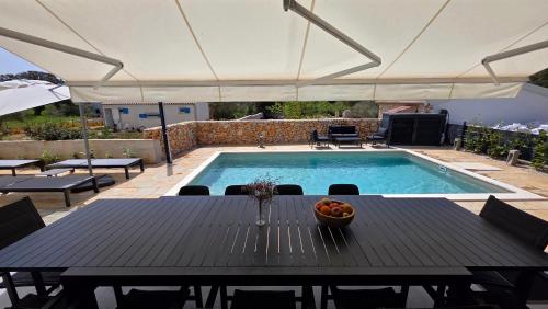 a table with a bowl of fruit next to a swimming pool at Residence Giardino in Ugljan