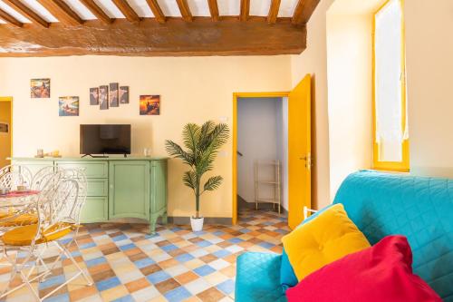 ein Wohnzimmer mit einem blauen Sofa und einem Fernseher in der Unterkunft Lago Trasimeno - La Casa del Pescatore - vicino a Perugia in San Feliciano