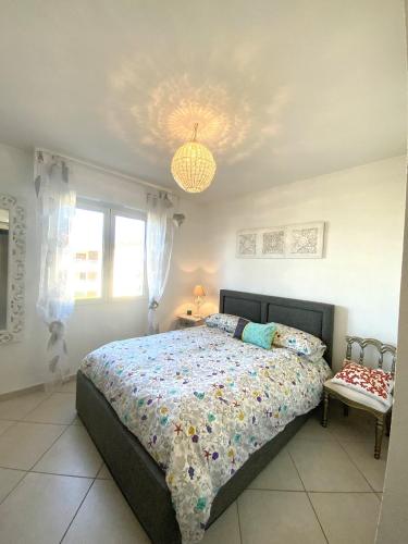 une chambre avec un lit et un lustre dans l'établissement Bel appartement à Ile Rousse, à LʼÎle-Rousse