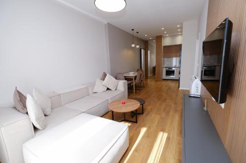 a living room with a white couch and a table at Albania Haven Apartment 20B in Tirana