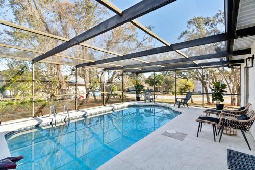 a swimming pool with chairs and a pergola at Luxury getaway, relax, and recharge! in Spring Hill