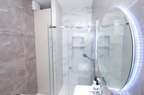 a bathroom with a shower with a mirror at Albania Haven Apartment 20B in Tirana