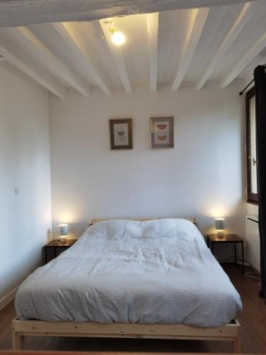 - une chambre blanche avec un lit et deux tables dans l'établissement Duplex 2 - Proche du Jardin des Plantes, à Rouen