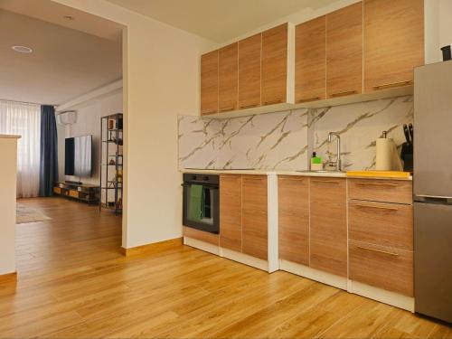 une cuisine avec des armoires en bois et des appareils en acier inoxydable dans l'établissement Apartman Trg 892, à Livno