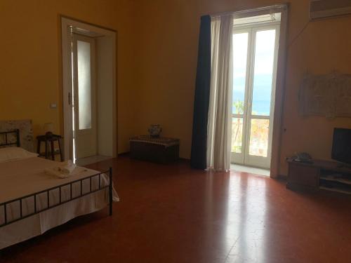a bedroom with a bed and a sliding glass door at B&B Rosita in Patti