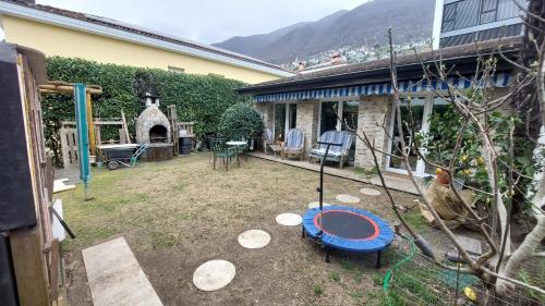 a yard with a swing and a house at Casa celeste, stanza in appartamento condiviso in Minusio