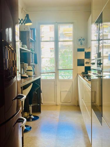 une cuisine avec une grande fenêtre et une porte dans l'établissement Le Palais Antibois, à Antibes