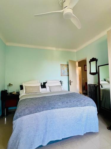 une chambre avec un grand lit avec un ventilateur de plafond dans l'établissement Le Palais Antibois, à Antibes