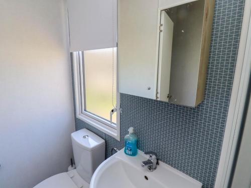 a bathroom with a sink and a mirror and a toilet at 10 Woodlands Way in Morpeth