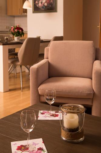 a table with two wine glasses and a couch at Ferienwohnung in Otterndorf in Otterndorf