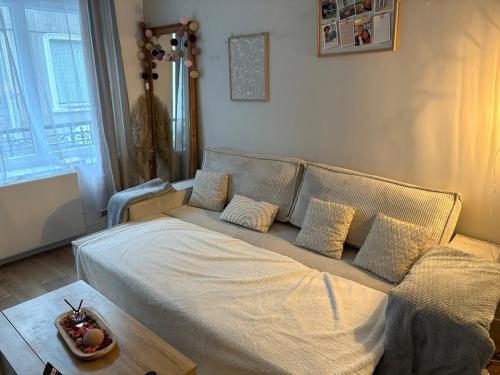 un lit avec des draps blancs et des oreillers dans une chambre dans l'établissement Maison cosy pour 2 à 4 personnes, proche de tout, à Boulogne-sur-Mer