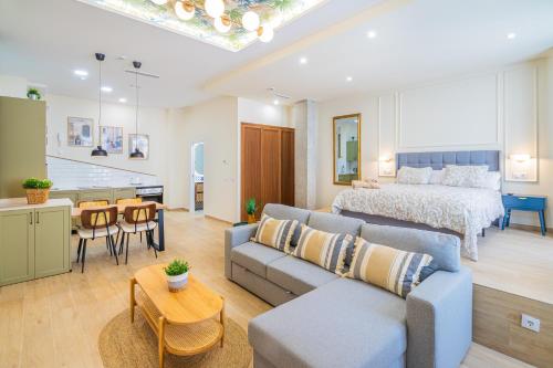 Il comprend un salon avec un canapé et un lit ainsi qu'une cuisine. dans l'établissement CARTAGENAFLATS - San Diego Suites, à Carthagène