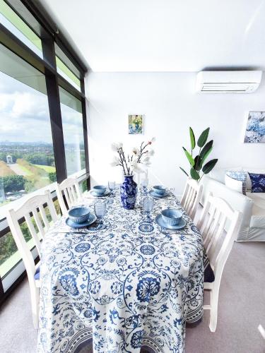 a dining room with a table with a blue and white table cloth at Hamptons Style 2BR & kid room w view in Olympic Park in Sydney