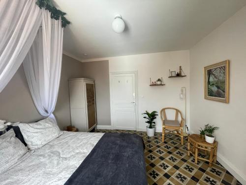 a bedroom with a bed and a chair at Les volets verts in Saint-Laurent-de-la-Cabrerisse