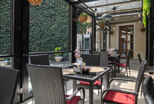 an outdoor patio with tables and chairs on a patio at Hotel Marabella in Sibiu