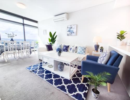 a living room with a couch and a table at Hamptons Style 2BR & kid room w view in Olympic Park in Sydney