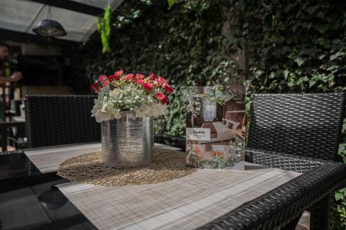 a table with a vase of flowers on top of it at Hotel Marabella in Sibiu