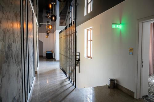 a hallway with a staircase in a building with a green light at Hotel Marabella in Sibiu