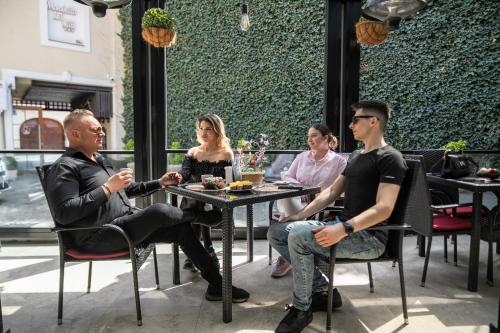 a group of people sitting at a table in a restaurant at Hotel Marabella in Sibiu