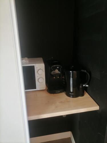 d'un comptoir avec un four micro-ondes et une cafetière. dans l'établissement Studio Baignoire centre ville, à Narbonne