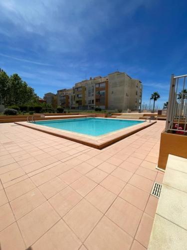 une grande piscine avec un bâtiment en arrière-plan dans l'établissement Studio le sergent, au Cap d'Agde