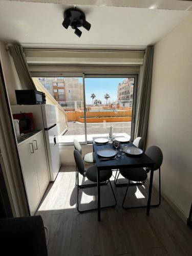 une salle à manger avec une table et des chaises et une fenêtre dans l'établissement Studio le sergent, au Cap d'Agde
