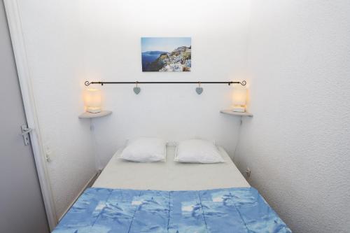 Cette petite chambre comprend un lit et deux lampes. dans l'établissement Charmant appartement T2 avec Balcon, à Saint-Cyprien