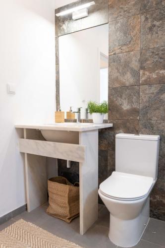 a bathroom with a white toilet and a mirror at CoWorking and CoLiving Villa in Sagres