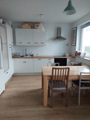 グダニスクにあるChillout u Malinyの木製のテーブルとテーブルと椅子のあるキッチン