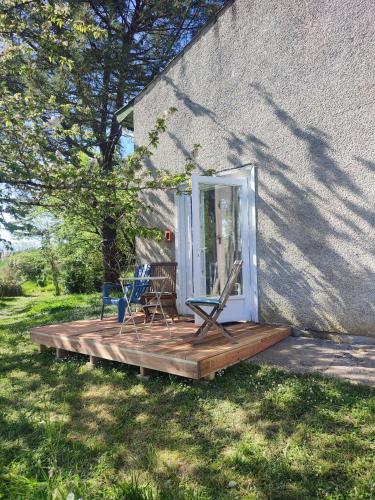 une terrasse couverte avec 2 chaises et une maison dans l'établissement Le home atelier d'artiste, à Saint-Hilaire-de-la-Noaille