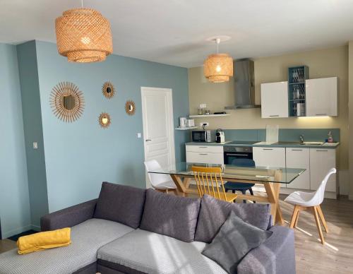 un salon et une cuisine avec un canapé et une table dans l'établissement La maison Virginie appartements climatisés de 1 à 5 pers cosy hyper centre cour parking linge fibre proximité port lac canal piscine, à Montargis