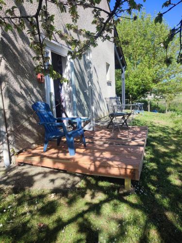 - une terrasse en bois avec 2 chaises bleues dans l'établissement Le home atelier d'artiste, à Saint-Hilaire-de-la-Noaille