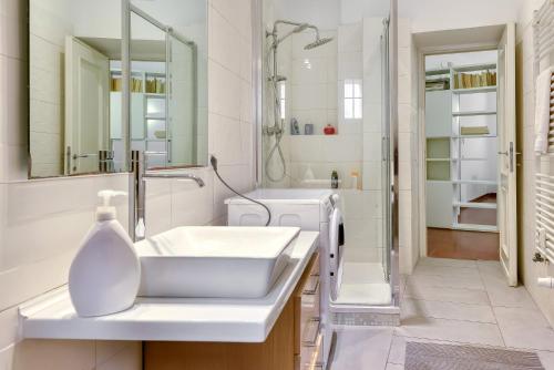 Un baño blanco con lavabo y ducha en Lavinia's Apartment at Colosseo, en Roma