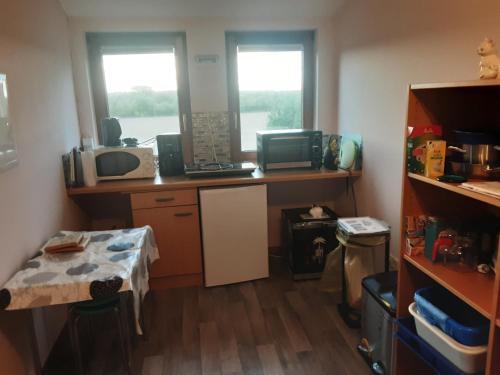 a small room with a desk and two windows at Gästezimmer von Annegret in Peine