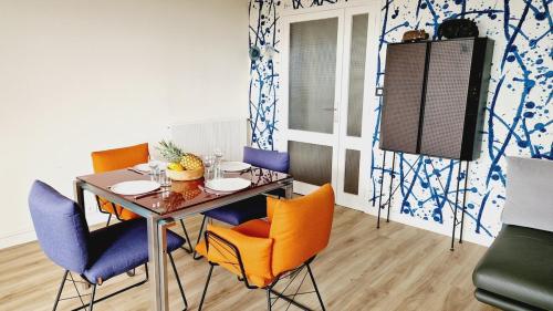 une salle à manger avec une table et quatre chaises dans l'établissement L'Orée - Bel appartement balcon vue mer et parking, à Les Sables-dʼOlonne