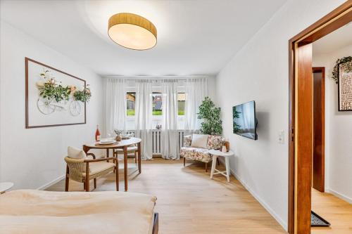 una sala de estar con una mesa y una silla en Black Forest Flower Apartment, en Bad Wildbad